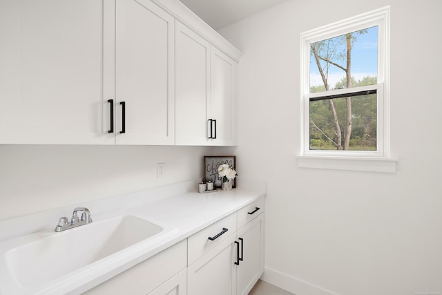 bar with white cabinetry, a wealth of natural light, and sink