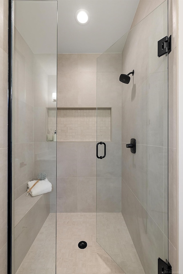 bathroom featuring a shower with door