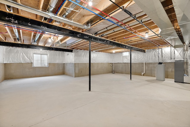 basement featuring water heater and heating unit