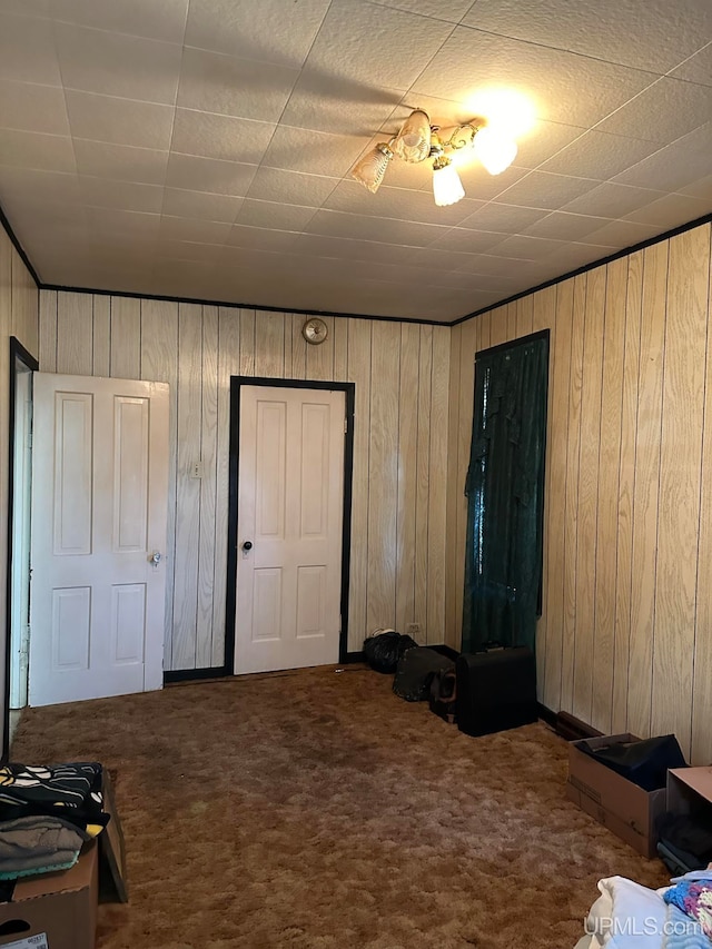 bedroom featuring carpet floors and wood walls