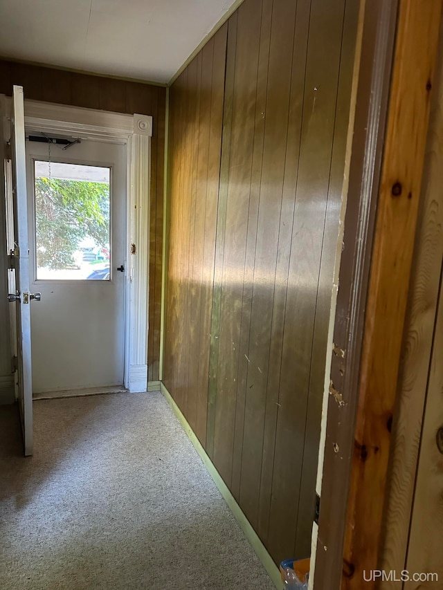 hall featuring carpet floors and wooden walls