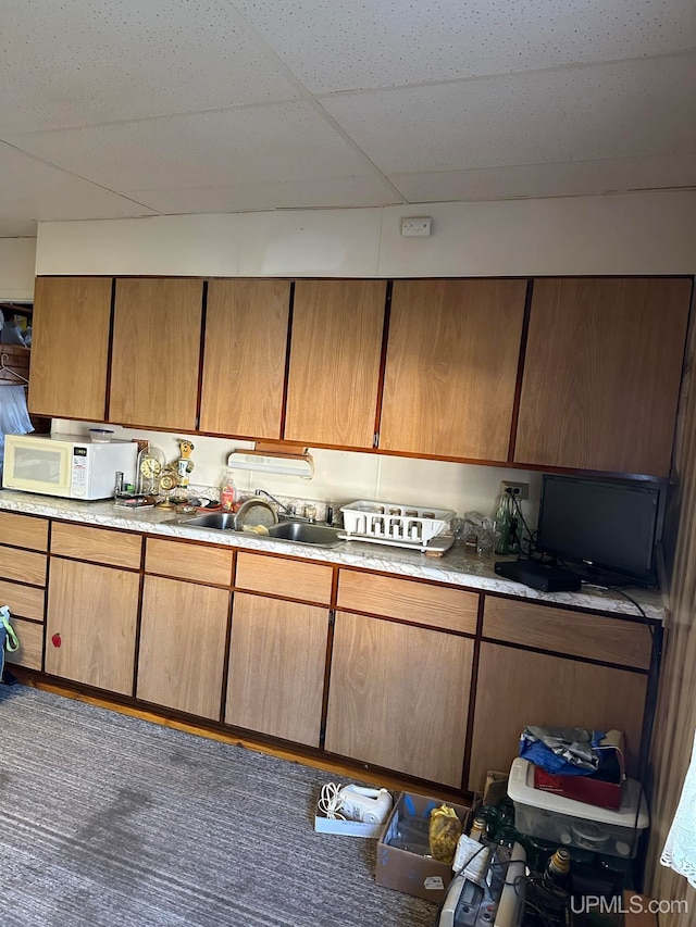 kitchen featuring a paneled ceiling and sink