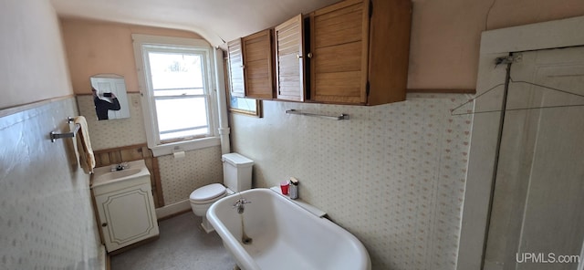 904 W A St, Iron Mountain, MI 49801 - bathroom featuring a tub to relax in, toilet, vanity, vaulted ceiling, and wallpapered walls