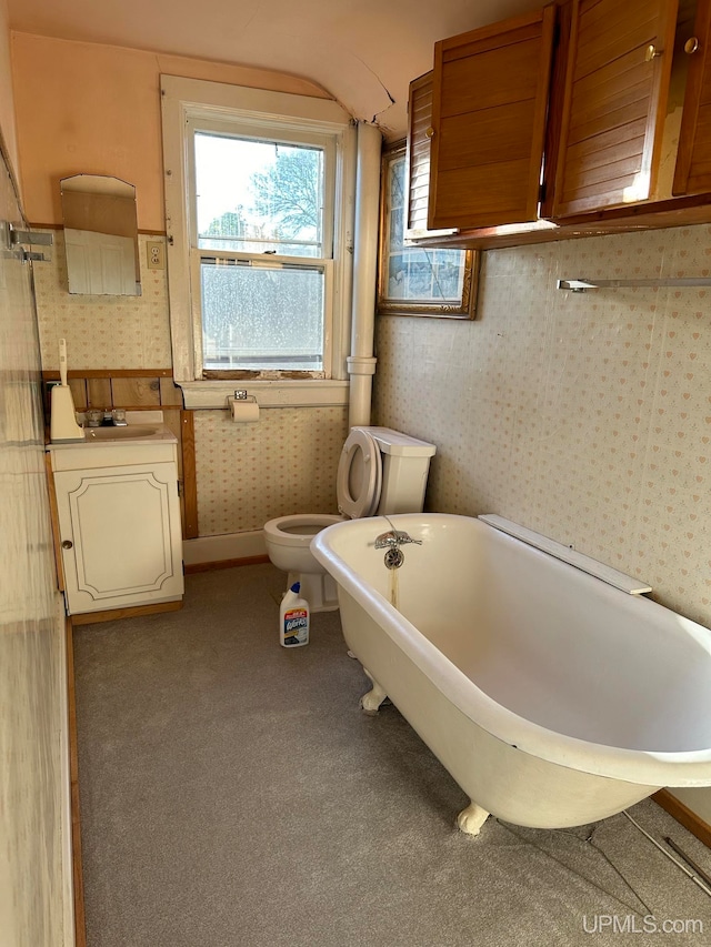 904 W A St, Iron Mountain, MI 49801 - bathroom featuring wallpapered walls, a soaking tub, vanity, lofted ceiling, and toilet