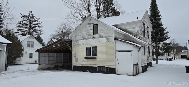 view of snow covered back of property