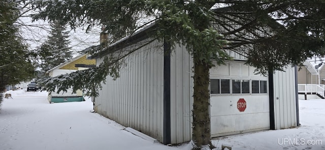 view of snow covered exterior featuring a garage