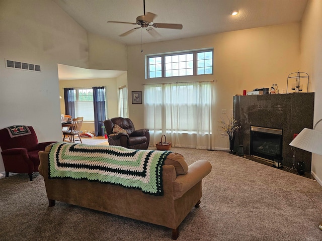 living room featuring a fireplace, high vaulted ceiling, ceiling fan, and carpet