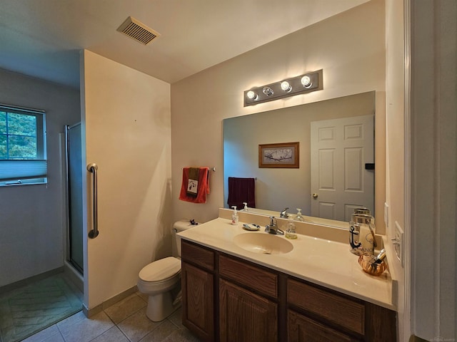 bathroom featuring vanity, toilet, an enclosed shower, and tile patterned floors