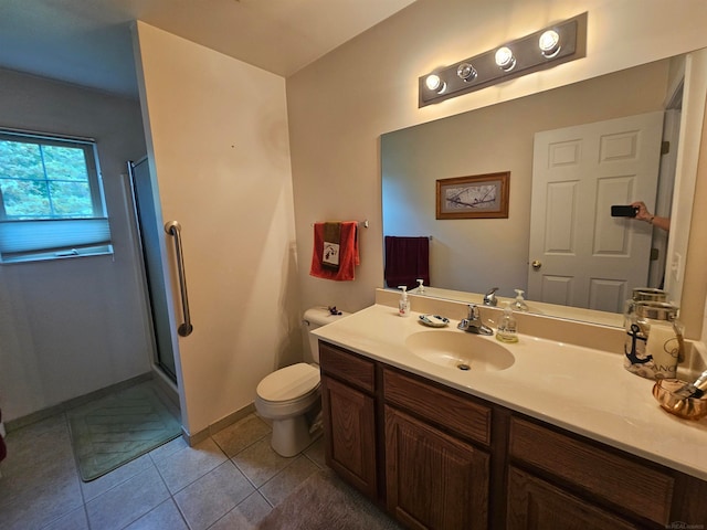 bathroom with a shower with door, vanity, toilet, and tile patterned floors