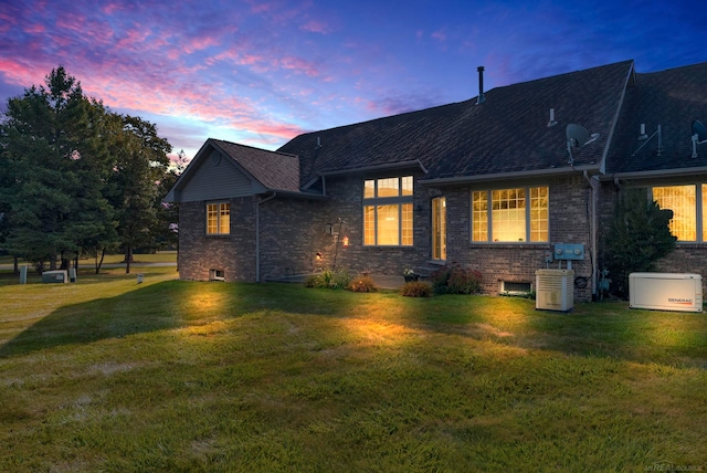 back house at dusk featuring a yard