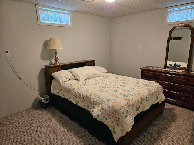 bedroom with a drop ceiling and carpet