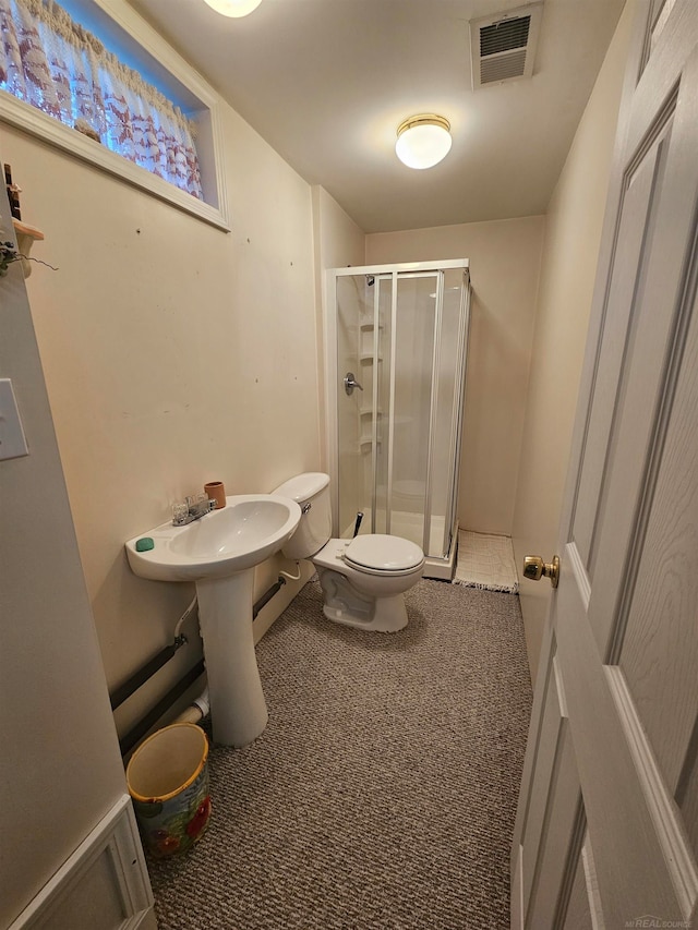 bathroom with a shower with shower door and toilet