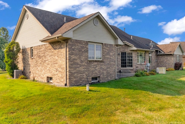 rear view of property with a lawn and central AC