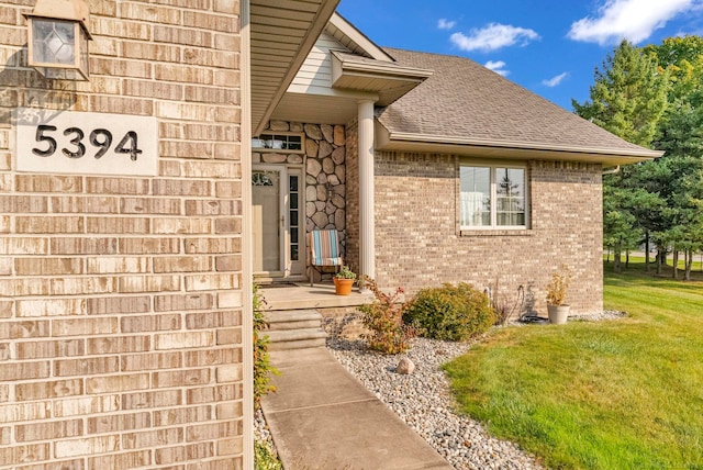 view of exterior entry with a lawn