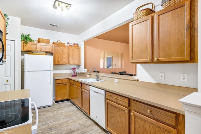 kitchen with light hardwood / wood-style flooring, sink, and white appliances