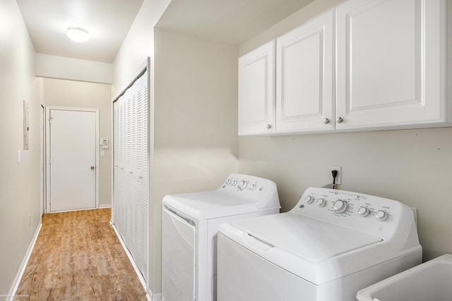 laundry room featuring cabinets, sink, light wood-type flooring, and washing machine and dryer