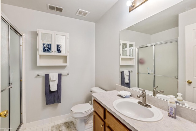 bathroom featuring tile patterned floors, toilet, a shower with door, and vanity