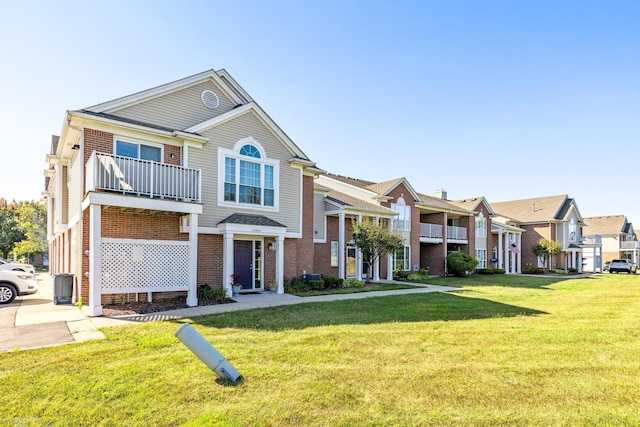 view of front of home with a front lawn and a balcony