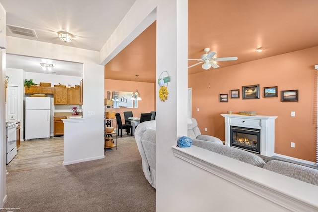 living room featuring light carpet and ceiling fan