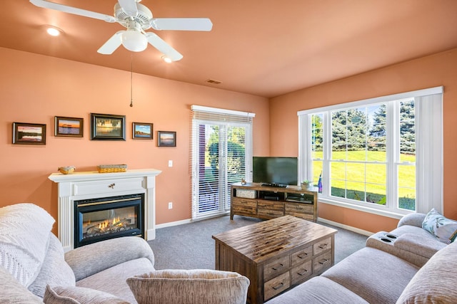 carpeted living room with ceiling fan