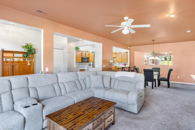 carpeted living room with ceiling fan