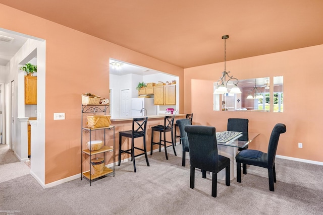 dining room featuring an inviting chandelier and light carpet