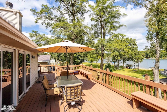 wooden terrace featuring a lawn and a water view