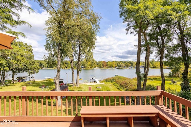 wooden terrace with a water view and a lawn