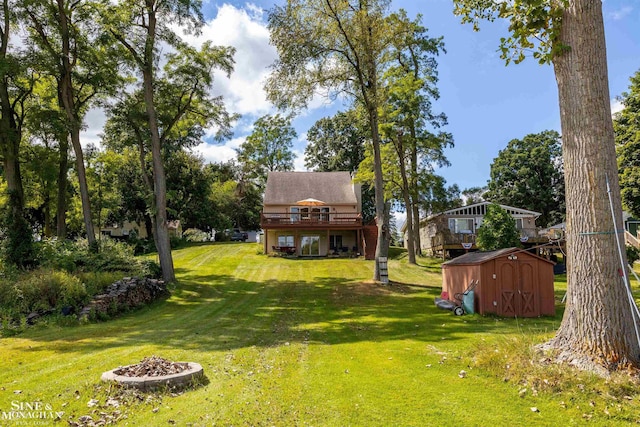 2771 Hemlock Rd, Quincy, MI 49082 - view of grassy yard with a wooden deck and an outdoor fire pit