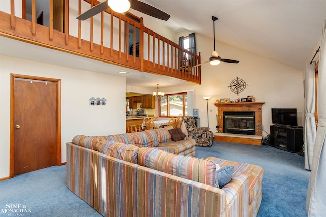 carpeted living room featuring ceiling fan with notable chandelier and high vaulted ceiling