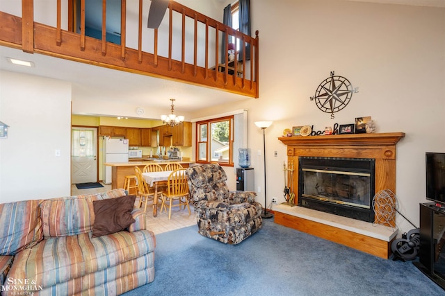 living room featuring a high ceiling, a notable chandelier, light carpet, and sink