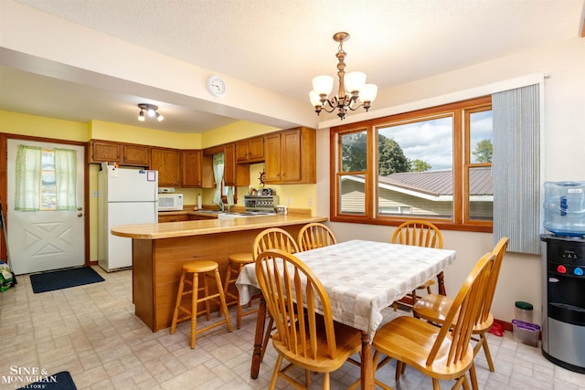 2771 Hemlock Rd, Quincy, MI 49082 - dining space featuring a chandelier and brick patterned flooring