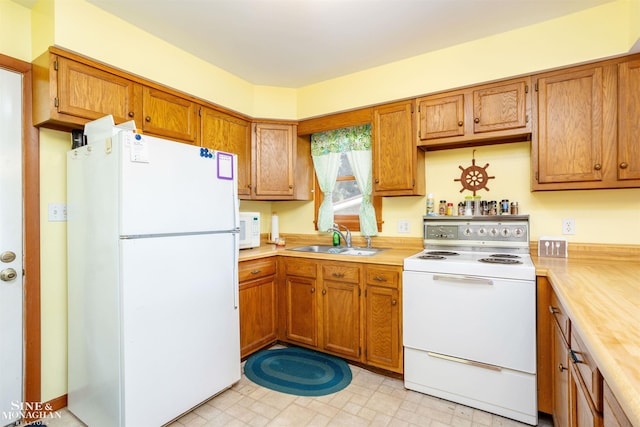 2771 Hemlock Rd, Quincy, MI 49082 - kitchen featuring white appliances, a sink, light countertops, brown cabinets, and light floors
