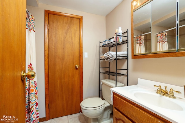 bathroom with vanity, toilet, and tile patterned floors