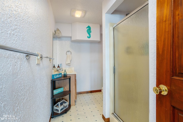 bathroom featuring a textured ceiling and an enclosed shower