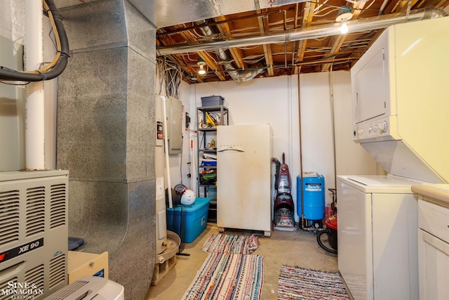 2771 Hemlock Rd, Quincy, MI 49082 - unfinished below grade area featuring freestanding refrigerator, stacked washer / drying machine, a water pressure tank, and heating unit