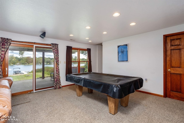 game room with light colored carpet, pool table, and a water view