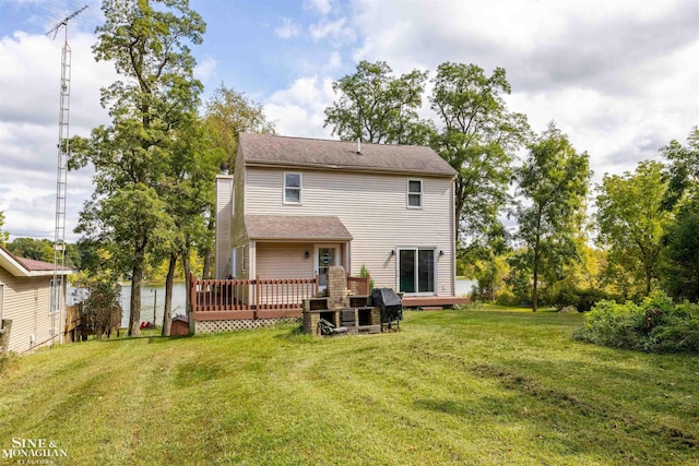 rear view of house featuring a yard and a wooden deck