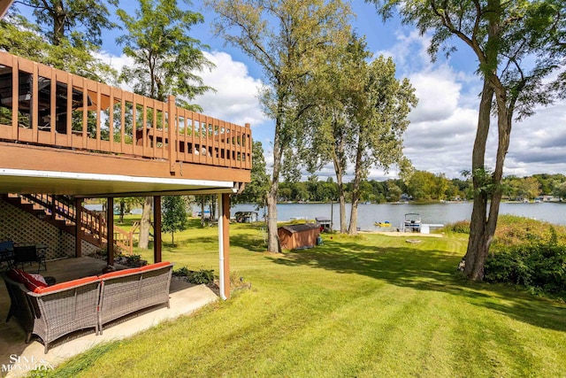 view of yard with a deck with water view