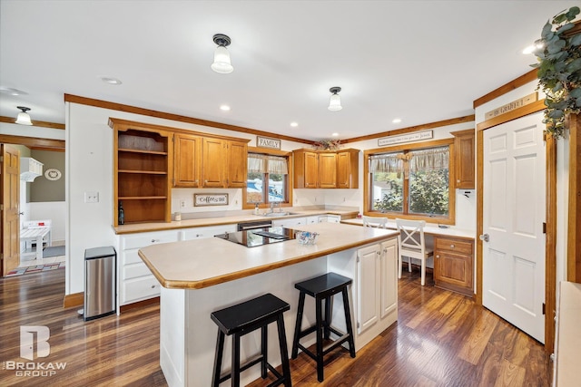 kitchen featuring a center island, a breakfast bar, sink, and dark wood-type flooring