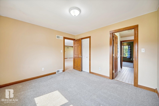 unfurnished bedroom featuring light carpet