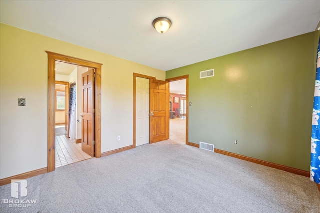 unfurnished bedroom with light colored carpet