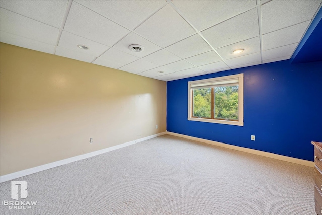 carpeted empty room featuring a paneled ceiling