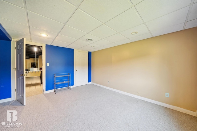 interior space featuring a paneled ceiling and carpet floors