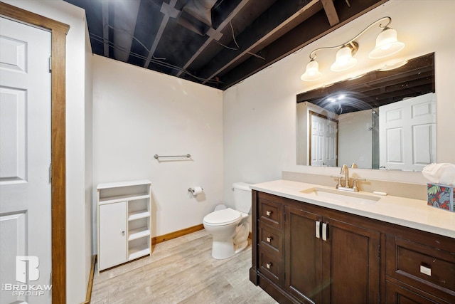 bathroom featuring vanity, toilet, and hardwood / wood-style flooring