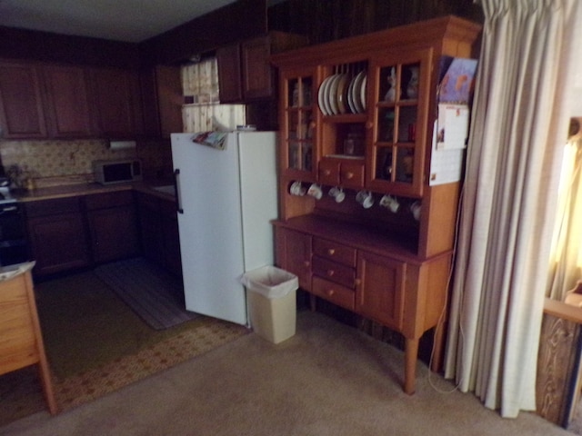 kitchen featuring light colored carpet and white fridge