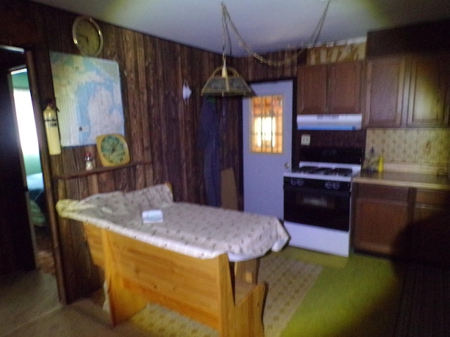 kitchen with a kitchen breakfast bar, decorative backsplash, and white gas stove