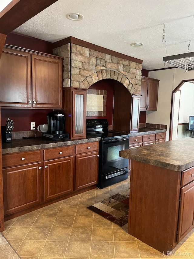 kitchen with black range with electric stovetop, a center island, tile patterned floors, and a textured ceiling