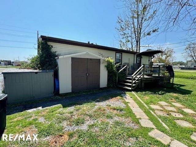 exterior space with a storage unit, a wooden deck, and a yard