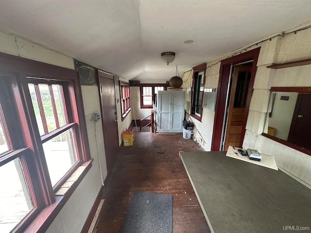 corridor featuring dark wood-type flooring and lofted ceiling